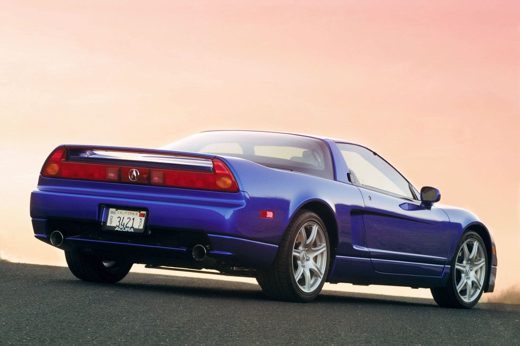 The rear 3/4 view of a blue 2005 Acura NSX-T with its roof on