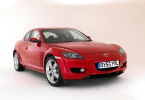 A red 2005 Mazda RX-8 parked in front of a white background. 