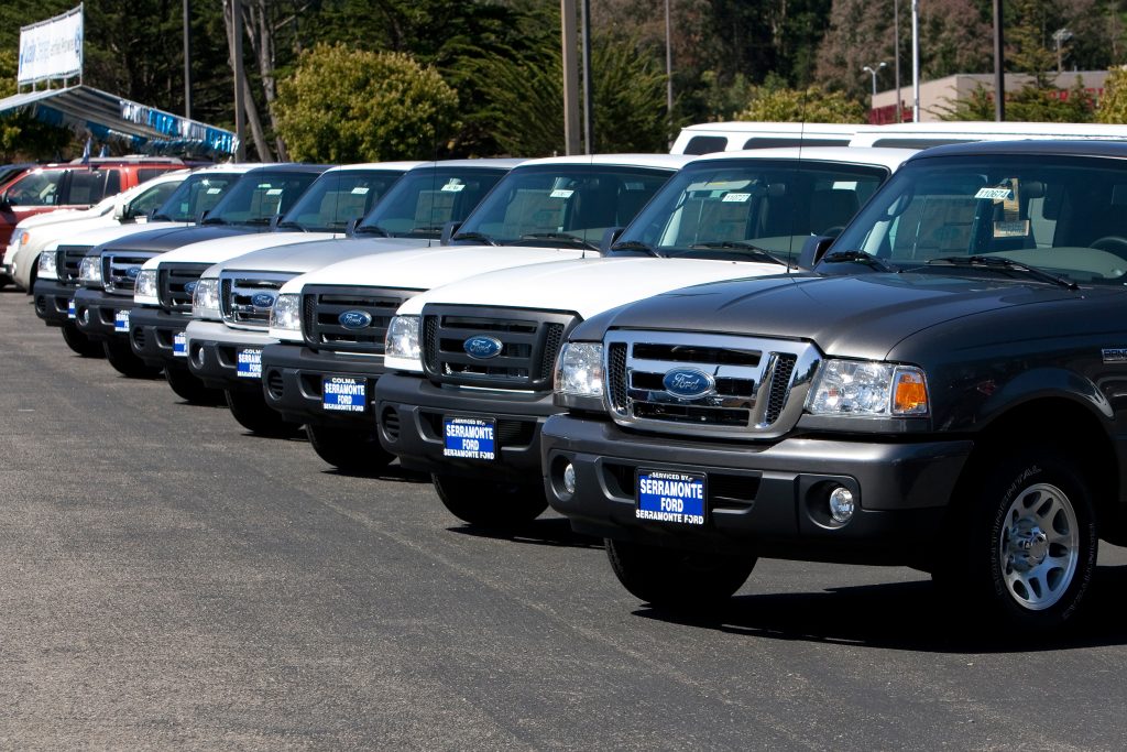 a dealer's lot loaded with 2011 Ford Ranger pickup truck models, the last generation before its discontinuation.