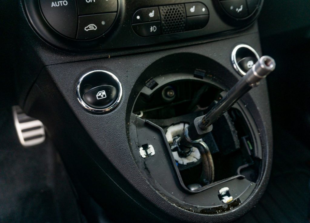 The stock shifter assembly in a 2013 Fiat 500 Abarth with the shifter boot removed