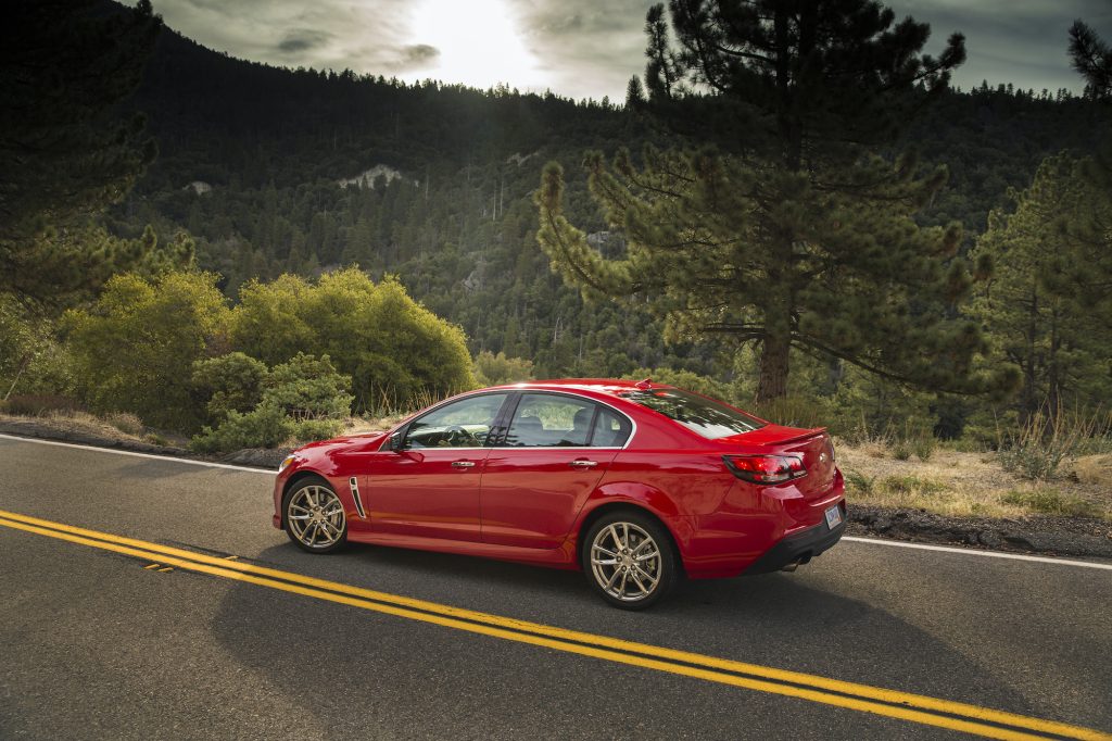2014 Chevrolet SS shown in red at a side angle on a road with trees