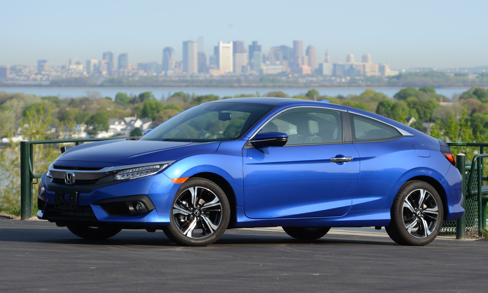 A blue 2016 Honda Civic coupe shot from the front 3/4 angle