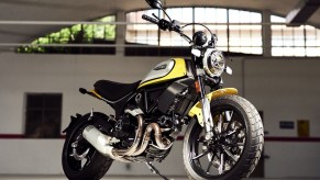 A yellow-black-and-silver 2021 Ducati Scrambler Icon in a garage