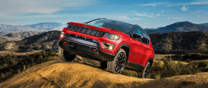 The 2021 Jeep Compass compact SUV driving off-road on desert hills of sand and dirt