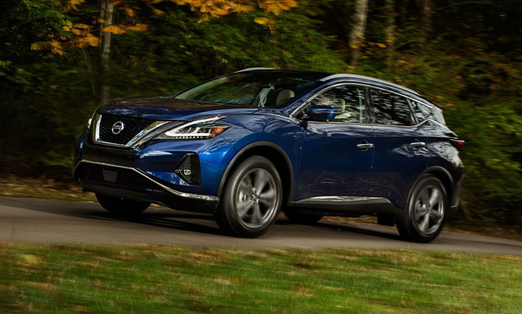 The 2021 Nissan Murano luxury midsize SUV with a blue paint color option driving on a forest park road