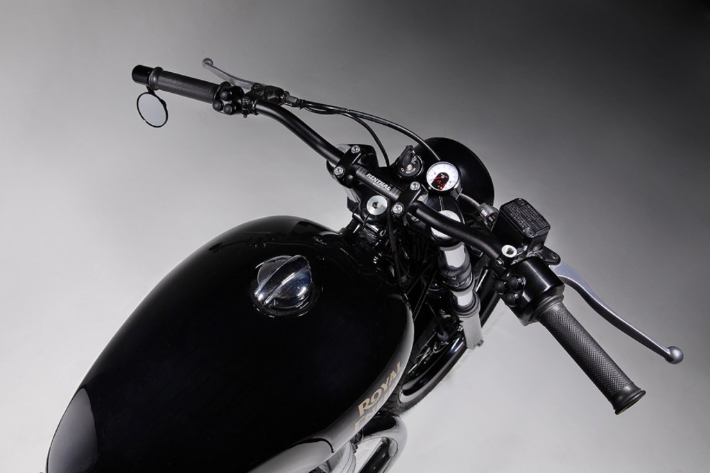 A close-up view of the Renthal handlebars and Motogadget instruments on a black 2021 Royal Enfield INT650 with Bad Winners kits