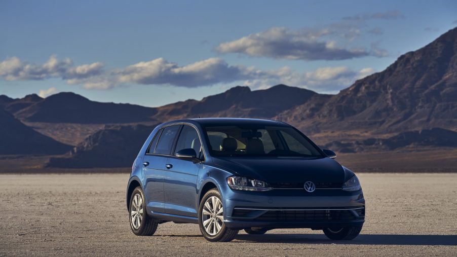 A dark turquoise blue 2021 Volkswagen Golf hatchback shot from the front 3/4 on a lake bed
