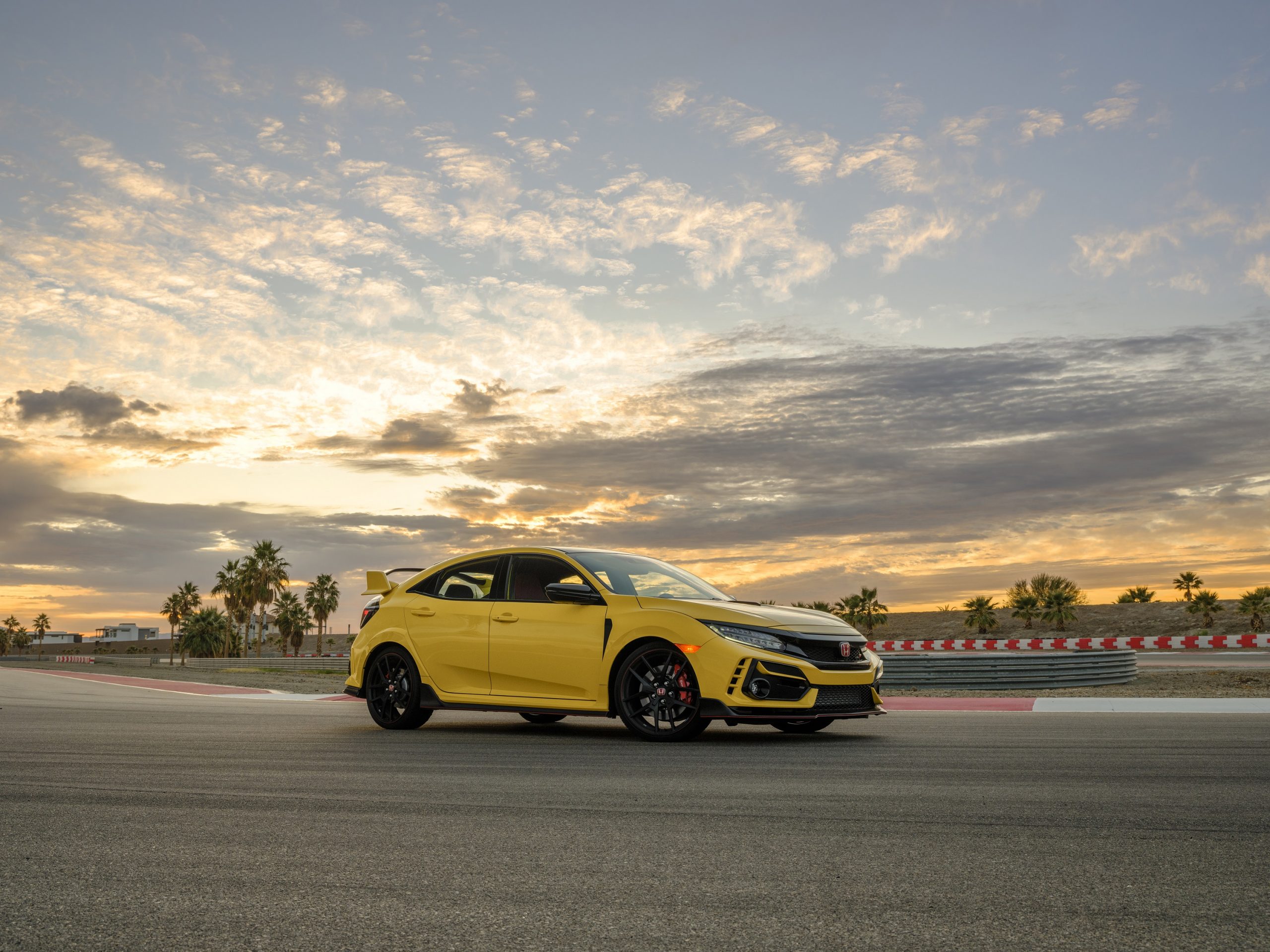 The 2021 Honda Civic Type R LE in yellow shot at sunset on a race track