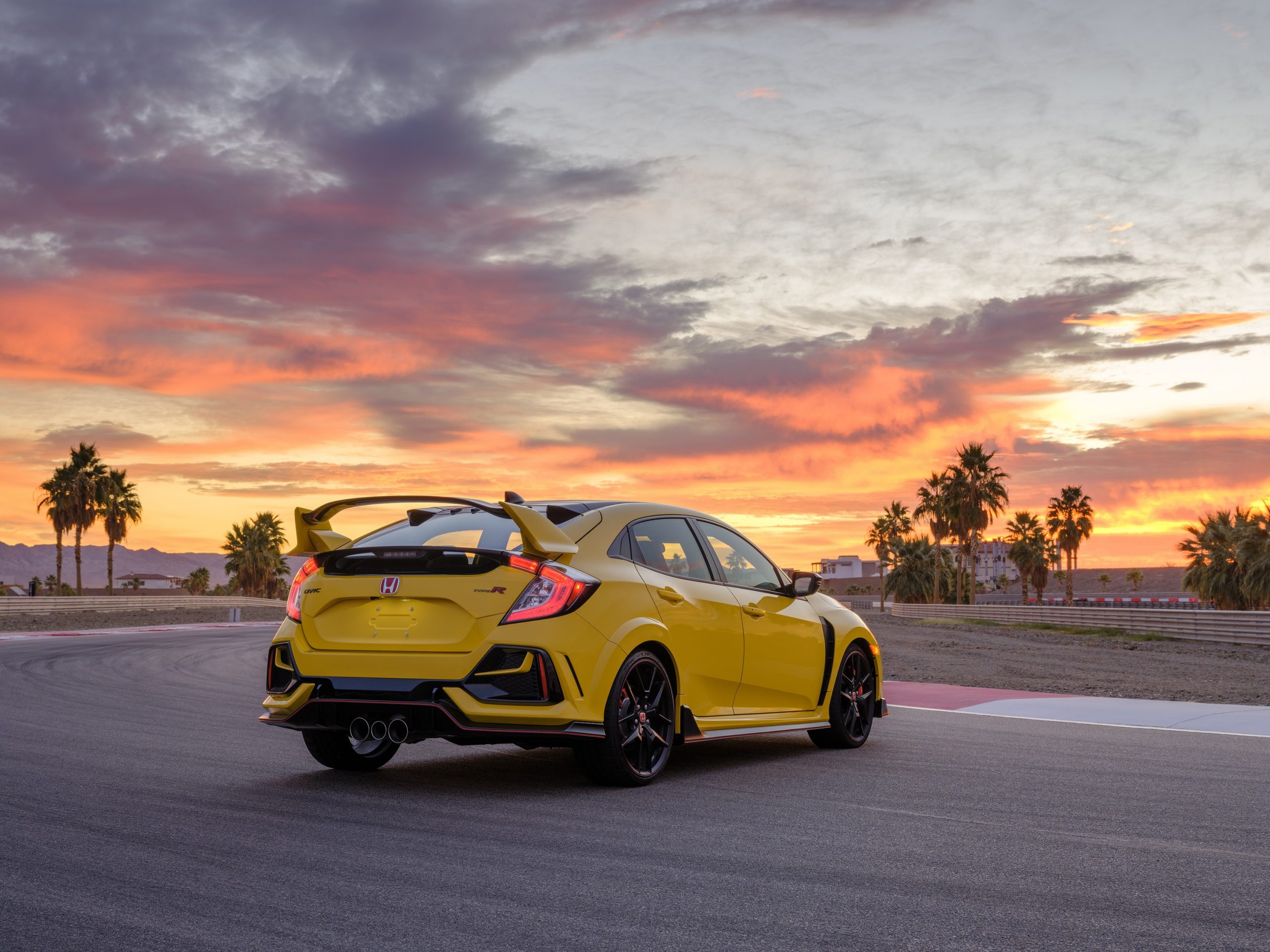 The rear of a Phoenix Yellow Honda Civic Type R, shot at sunset on a race track