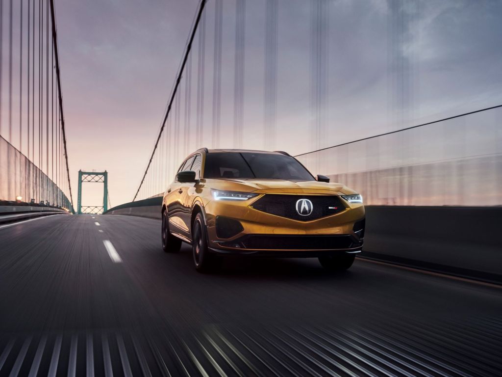 The 2022 Acura MDX Type S three-row performance crossover with a burnt orange/bronze paint color option driving over a bridge, is it worth the price?