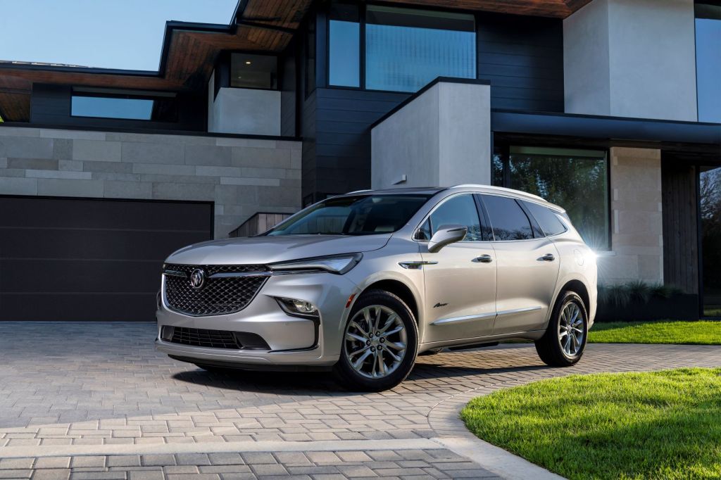 The 2022 Buick Enclave midsize SUV parked on a cobblestone driveway outside of a luxury home