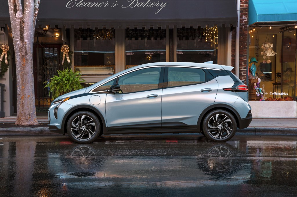 A silver 2022 Chevrolet Bolt EV is parked on a wet road. 