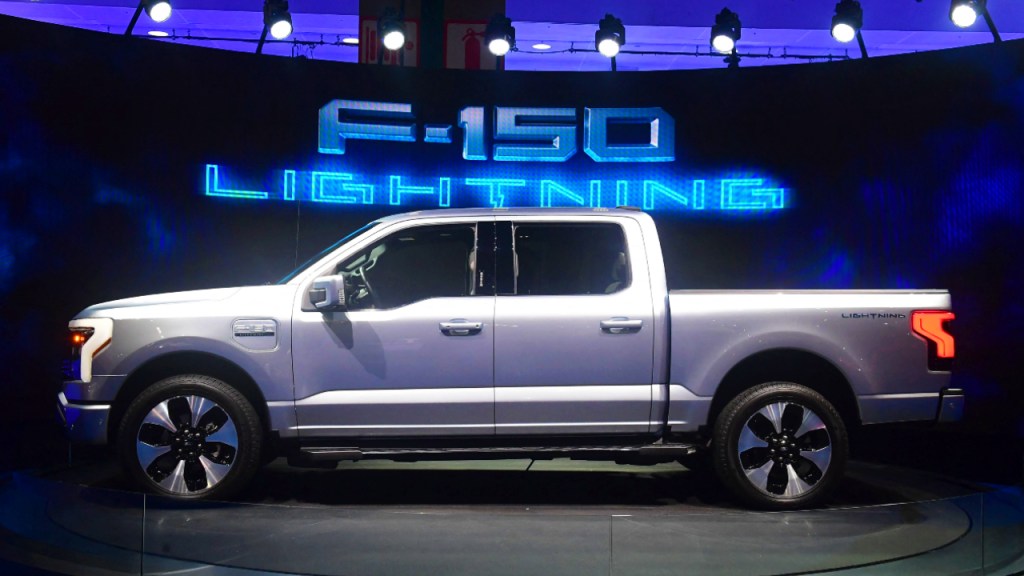 A silver 2022 Ford F-150 Lightning is on display, do electric pickup trucks have a good driving range?
