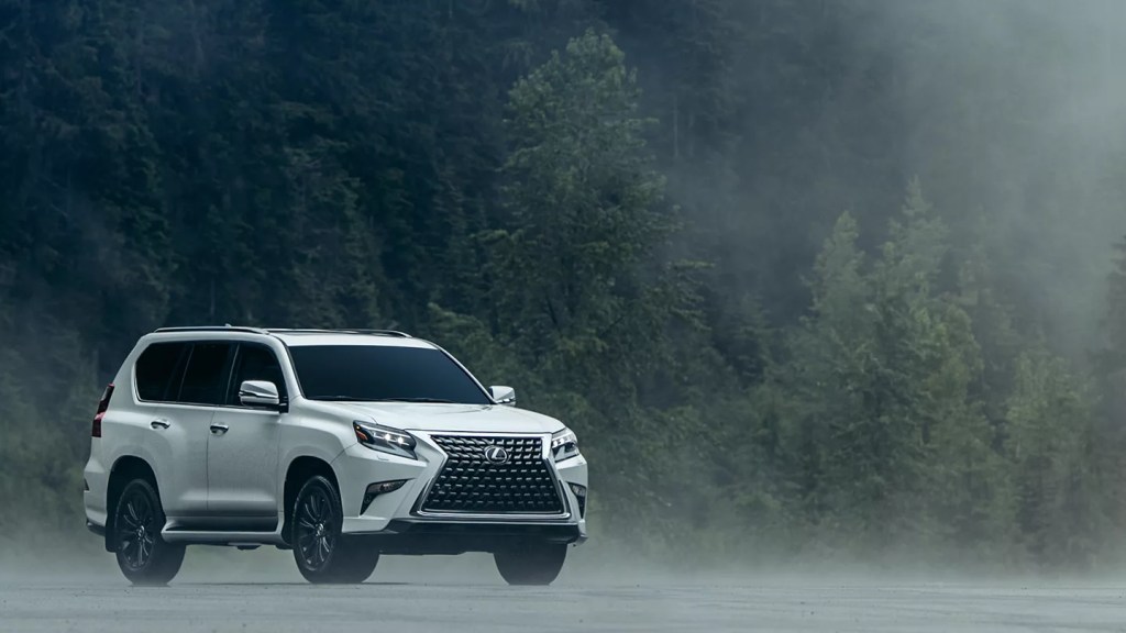 A white 2022 Lexus GX in front of misty trees.