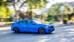 A blue 2022 Honda Civic shot in motion from profile