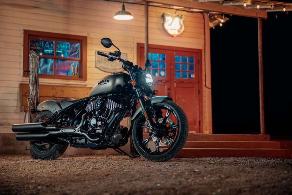 Our 2022 Indian Chief Dark Horse review unit is a top-tier cruiser. This one is parked in front of an old-timey building at night. 