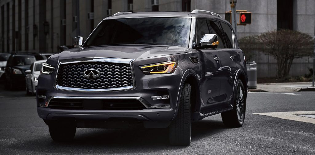 A Gray 2022 Infiniti QX80 turning through an intersection in the city