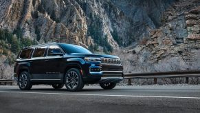 A black 2022 Jeep Grand Wagoneer drives alongside a mountain background, it is being recalled.