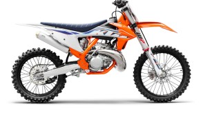 The side view of an orange-white-and-blue 2022 KTM 250 SX motocross 2-stroke dirt bike