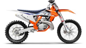 The side view of an orange-white-and-blue 2022 KTM 250 SX motocross 2-stroke dirt bike