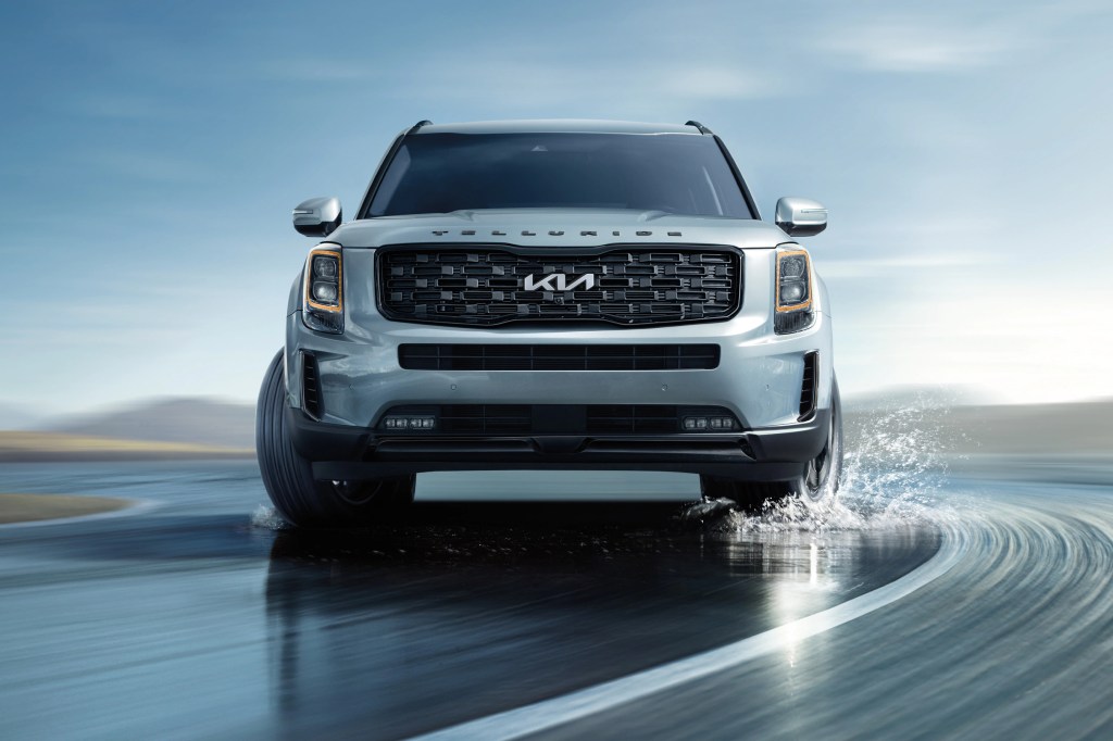 A 2022 Kia Telluride midsize SUV driving on the road with water on it, what's new for 2022?