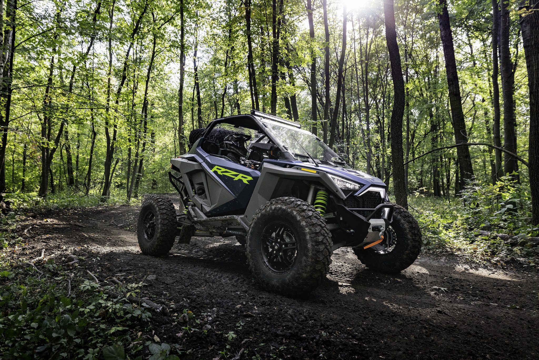 A green-and-gray 2022 Polaris RZR Turbo R Premium in the forest