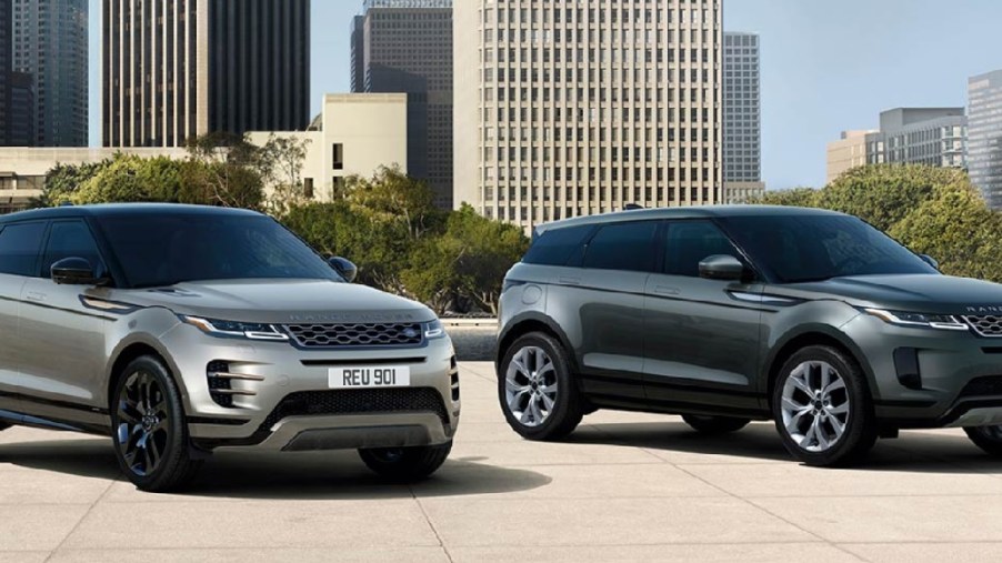 A gold and a gray 2022 Land Rover Range Rover Evoques parked with a city in the background.