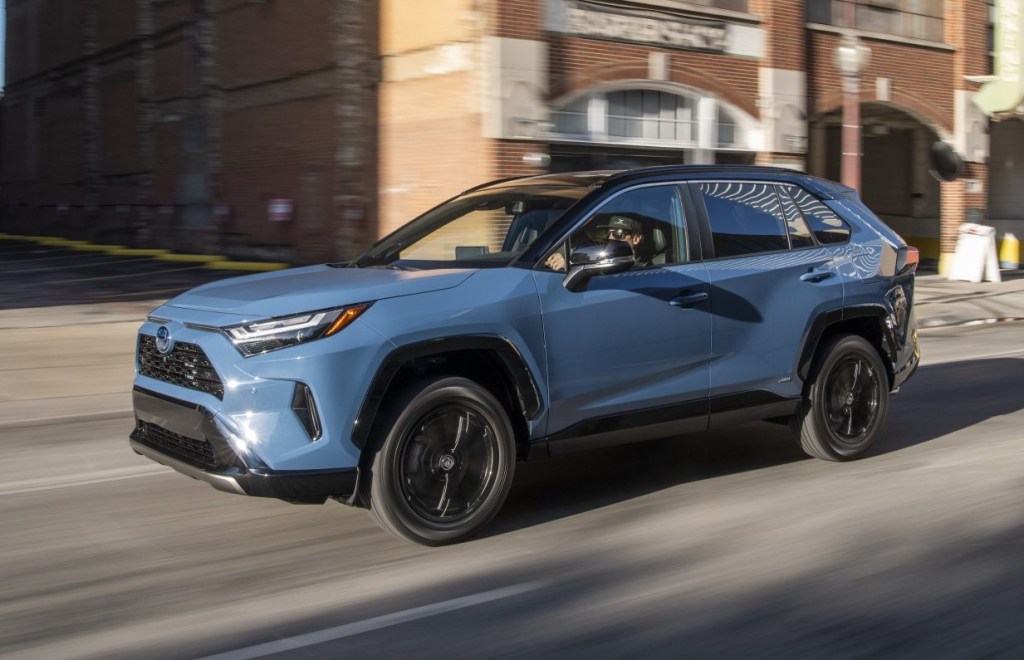2022 Toyota RAV4 with Cavalry Blue color option driving by a brick building