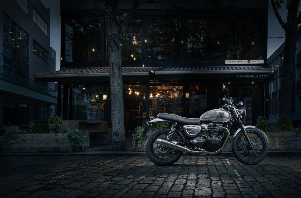 The side view of a gray-and-silver 2022 Triumph Street Twin EC1 Special Edition in front of a London East End shop