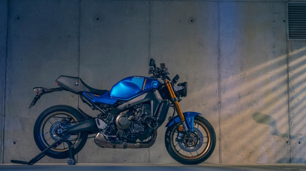 The side view of a blue-and-black 2022 Yamaha XSR900 on a rear-wheel stand in a garage