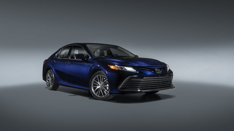 A dark blue 2022 Toyota Camry shot from the front 3/4 in a photo booth