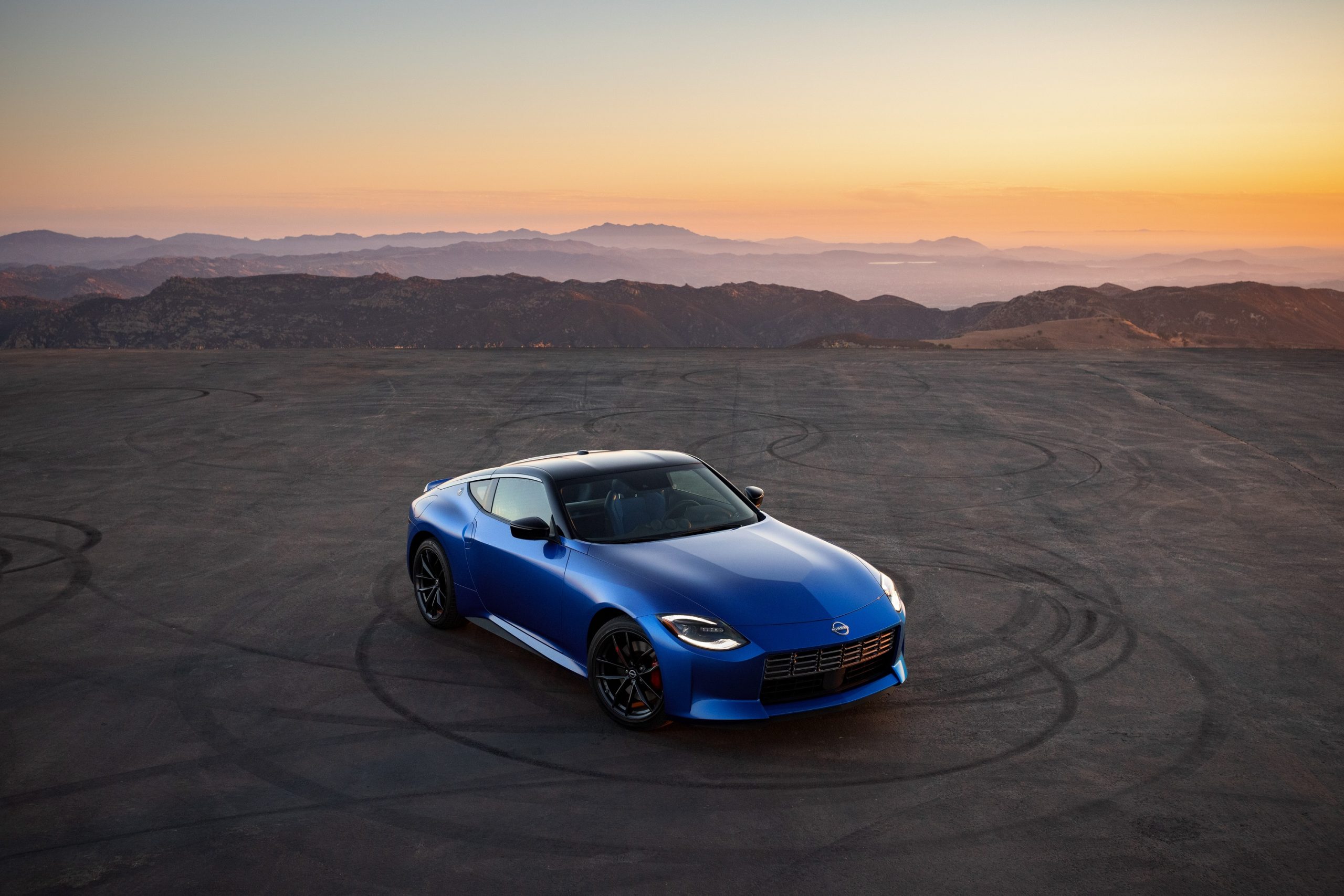 A blue 2023 Nissan Z shot from the high 3/4 angle at sunset