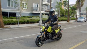 A rider rides a 2022 Honda Navi through a city street
