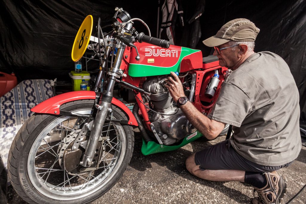 A mechanic works on a classic Ducati motorcycle