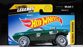 The side view of the green 'Ain't No Saint' 1969 Volvo P1800 gasser in front of a Hot Wheels Legends Tour sign