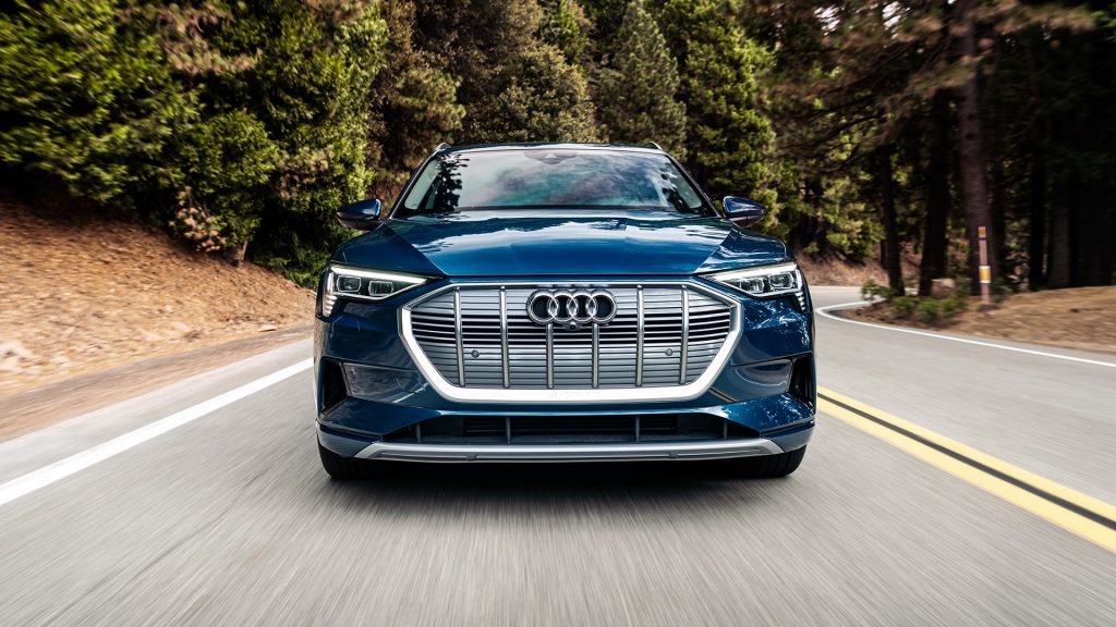 Blue 2022 Audi e-tron electric compact SUV driving on a forest road