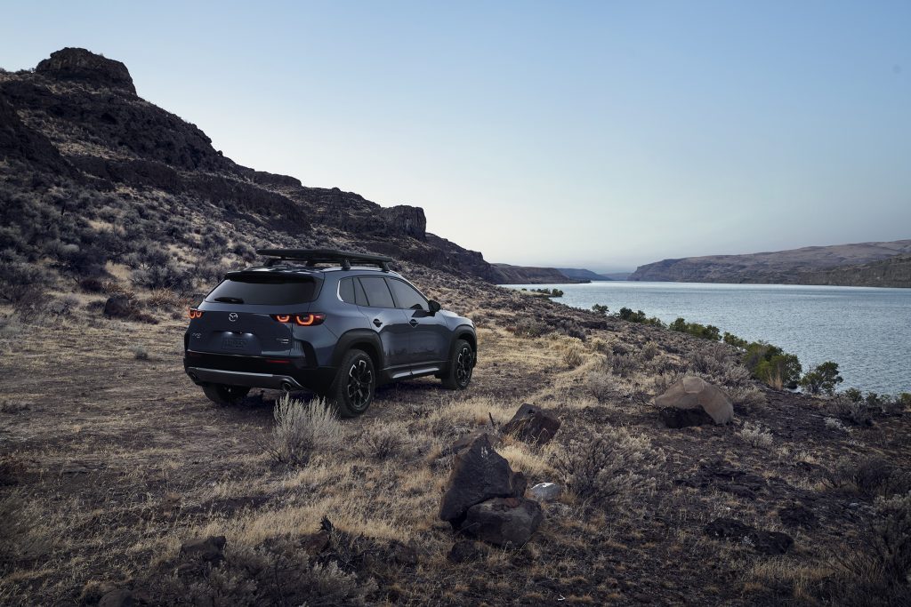 Blue 2023 Mazda CX-50 driving near a river