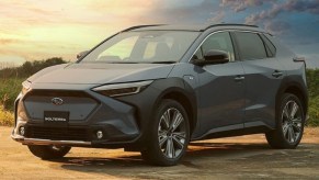 Blue-gray 2023 Subaru Solterra EV parked near a field, for information on release date, price, and specs