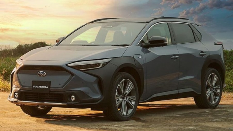 Blue-gray 2023 Subaru Solterra EV parked near a field, for information on release date, price, and specs