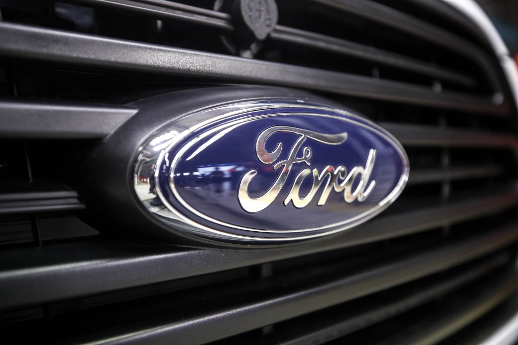 A blue Ford logo is on the grille of a vehicle. 