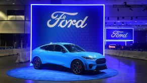 A blue Ford Mustang Mach-E electric SUV is on display.