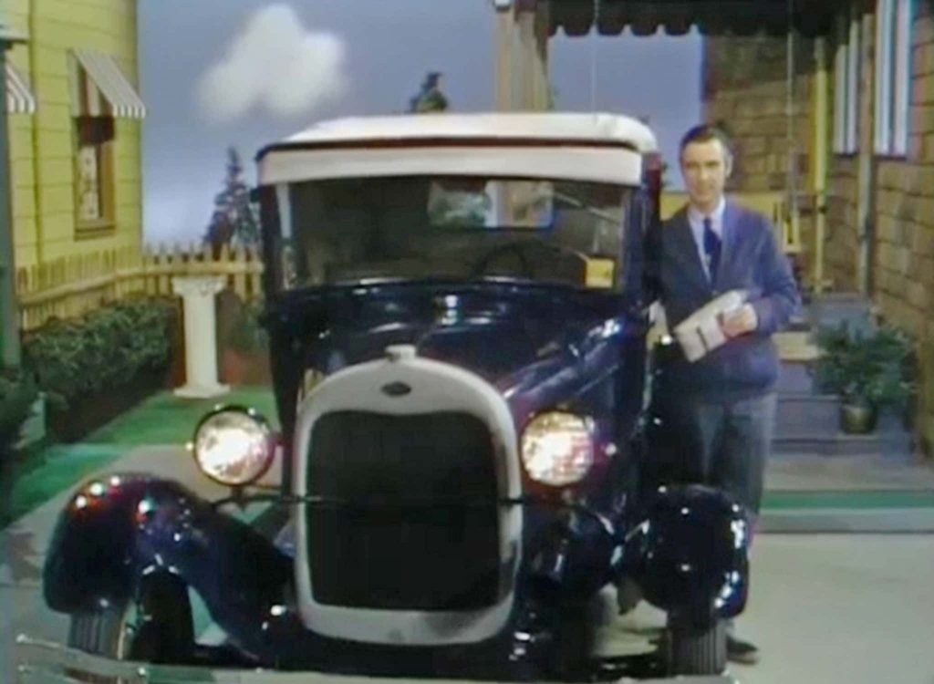 Fred Rogers standing next to a navy blue 1928 Ford Model A Sport Coupe in Mister Rogers' Neighborhood