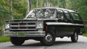 A black 1976 GMC Suburban Sierra.