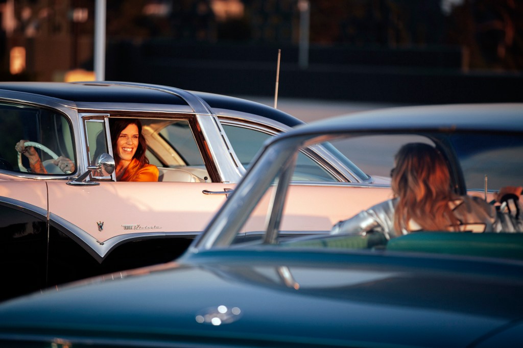 Two girls talking from their vintage Fords