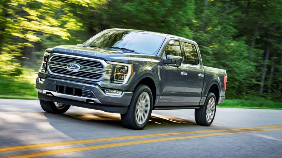Gray 2022 Ford F-150 Limited driving by a forest