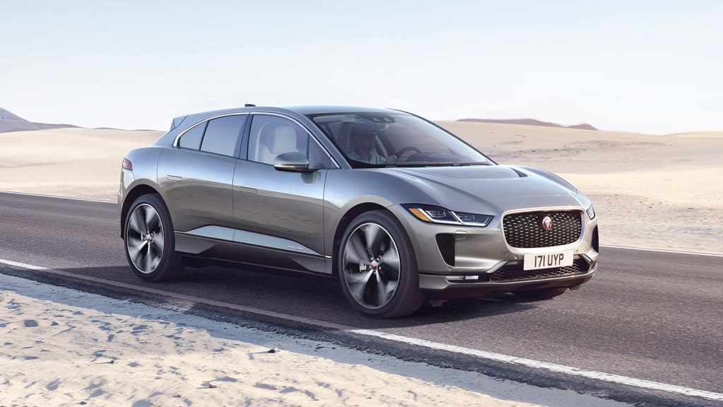 Gray 2022 Jaguar I-PACE electric crossover driving by sand dunes