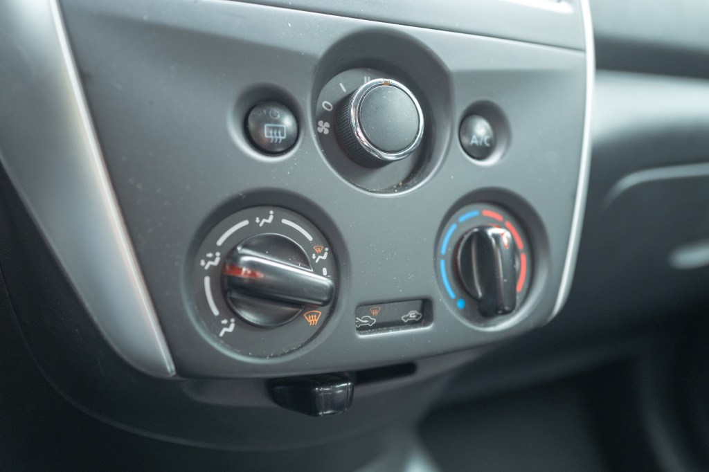 Knobs of automobile climate control system on the center console of Nissan automobile.