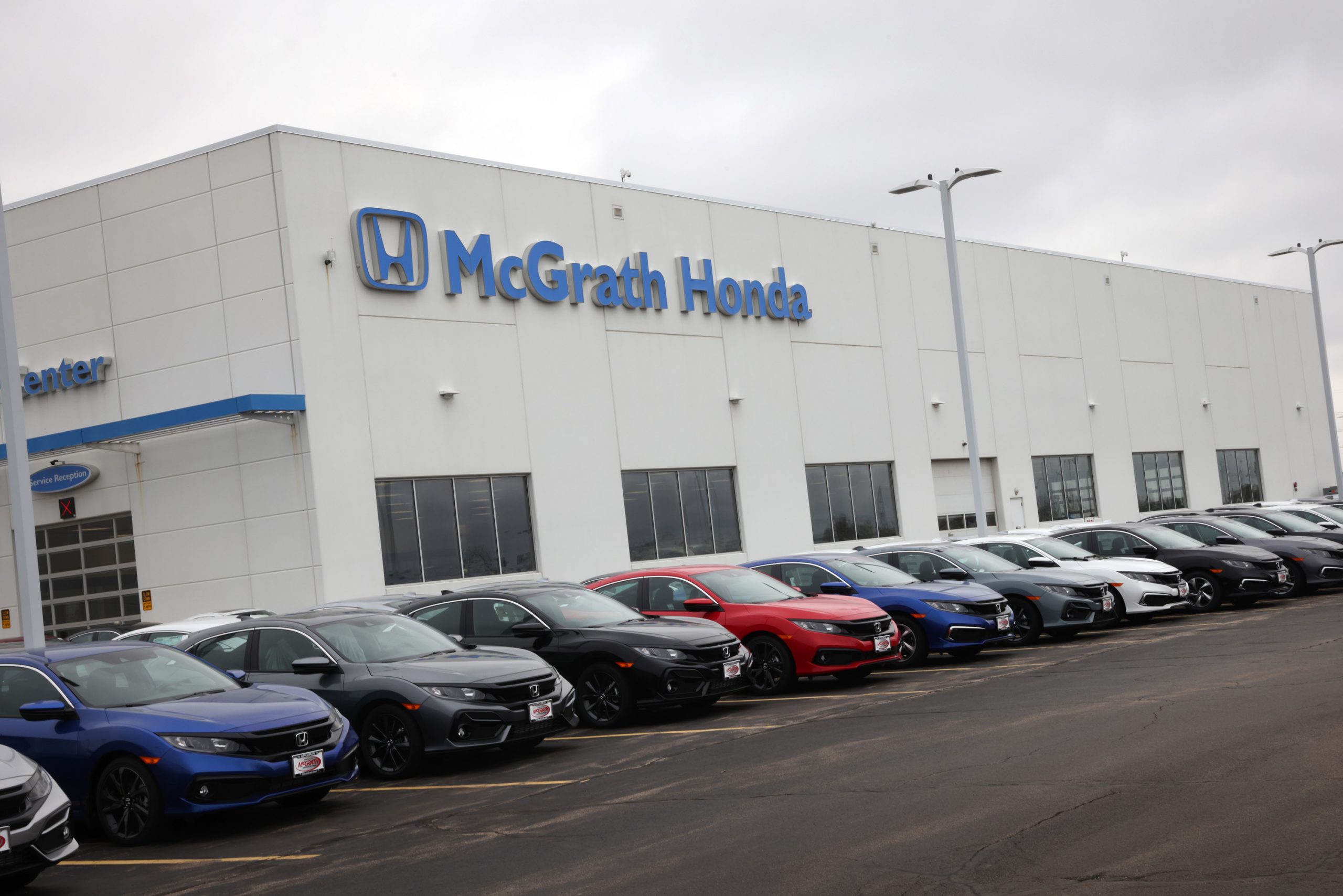 A row of Civic models on a Honda dealership lot
