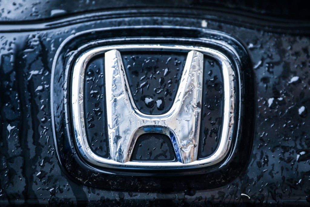 A chrome Honda logo on a black background.