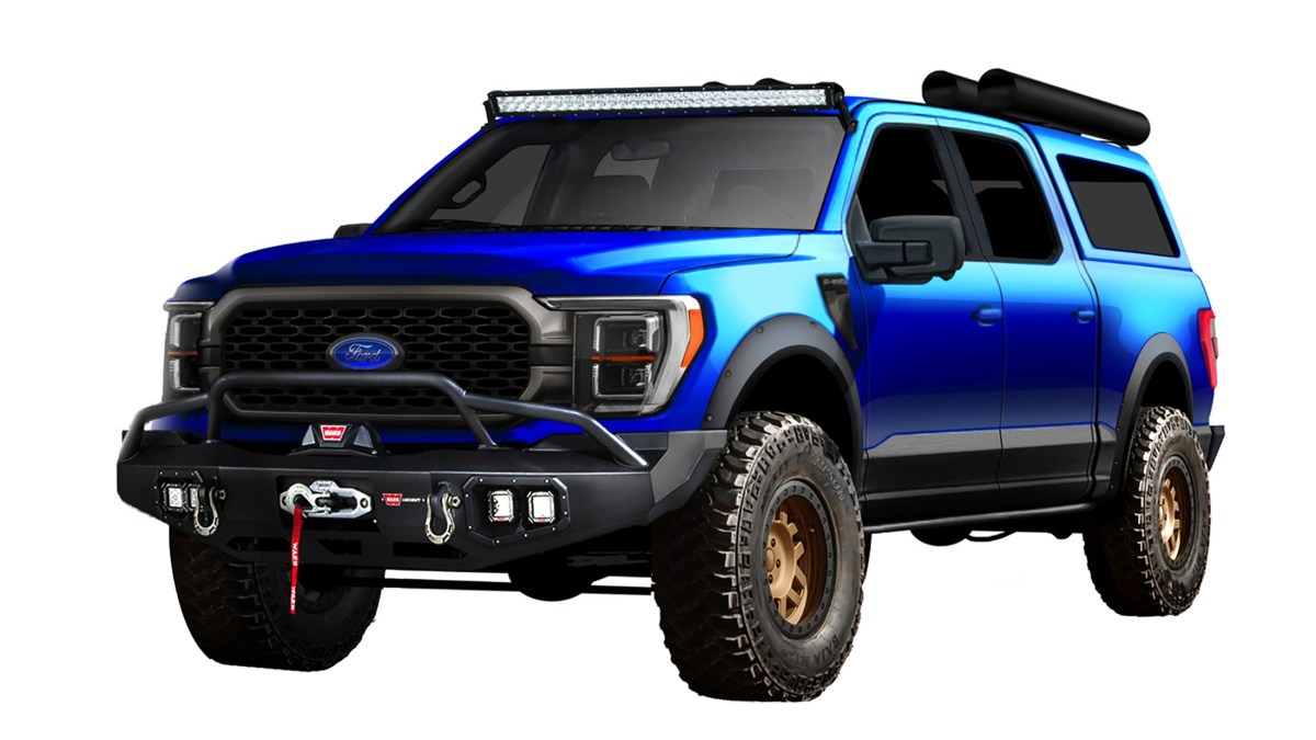 A metallic blue 2022 Ford F-150 truck with off-road front bumpers, lifted suspension, off road wheels and tires. There is a black roof rack with large black cylinders attached for storage. This truck will be on display at SEMA 2021